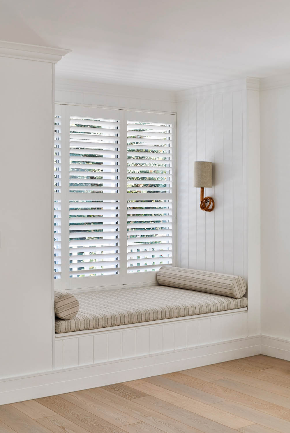 A window seat in the bay window of a residential home.