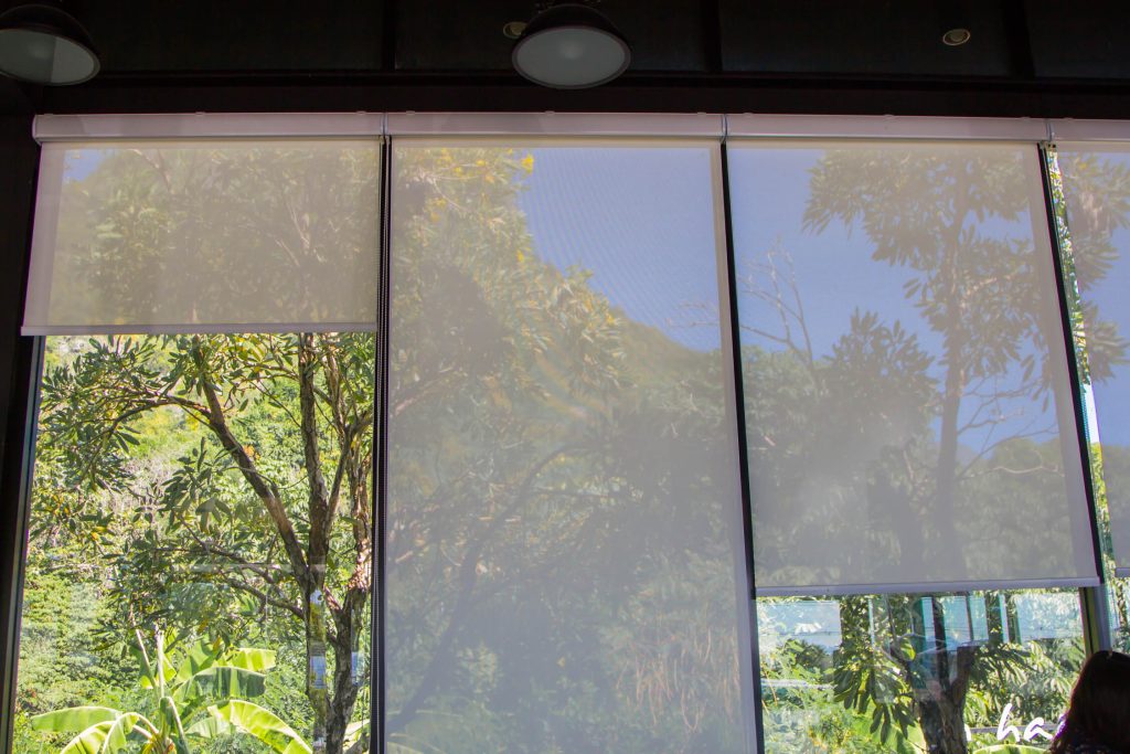 white roller blinds or curtains at the glass window