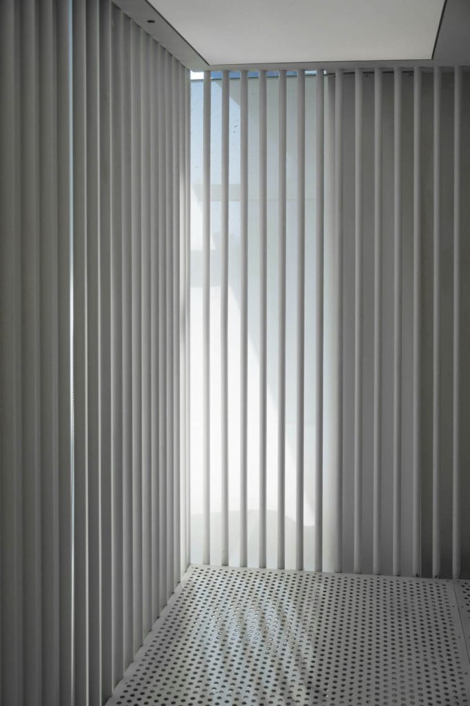 Minimalist room with vertical blinds and soft natural light streaming in.